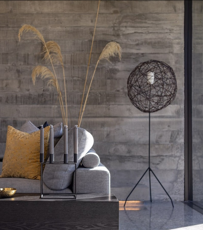 polished concrete floor new zealand architecture NZ Architecture polished concrete floors image of a polished concrete floor in loumnge area with a safa and floor lamp in background. Pampas grass is in a vase behind tje sofa and candles are on the coffee table in a candlestick holder