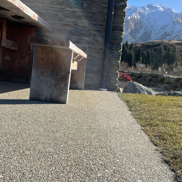 IMG_9992 an external patio floor bush hammered for texture with the snow capped mountains in the background and a bench seat in the foreground