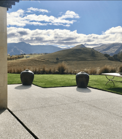 residential outdoor polished concrete tauranga nz grinders outdoor polished concrete floor with 2 pots in background and a view of a mountain