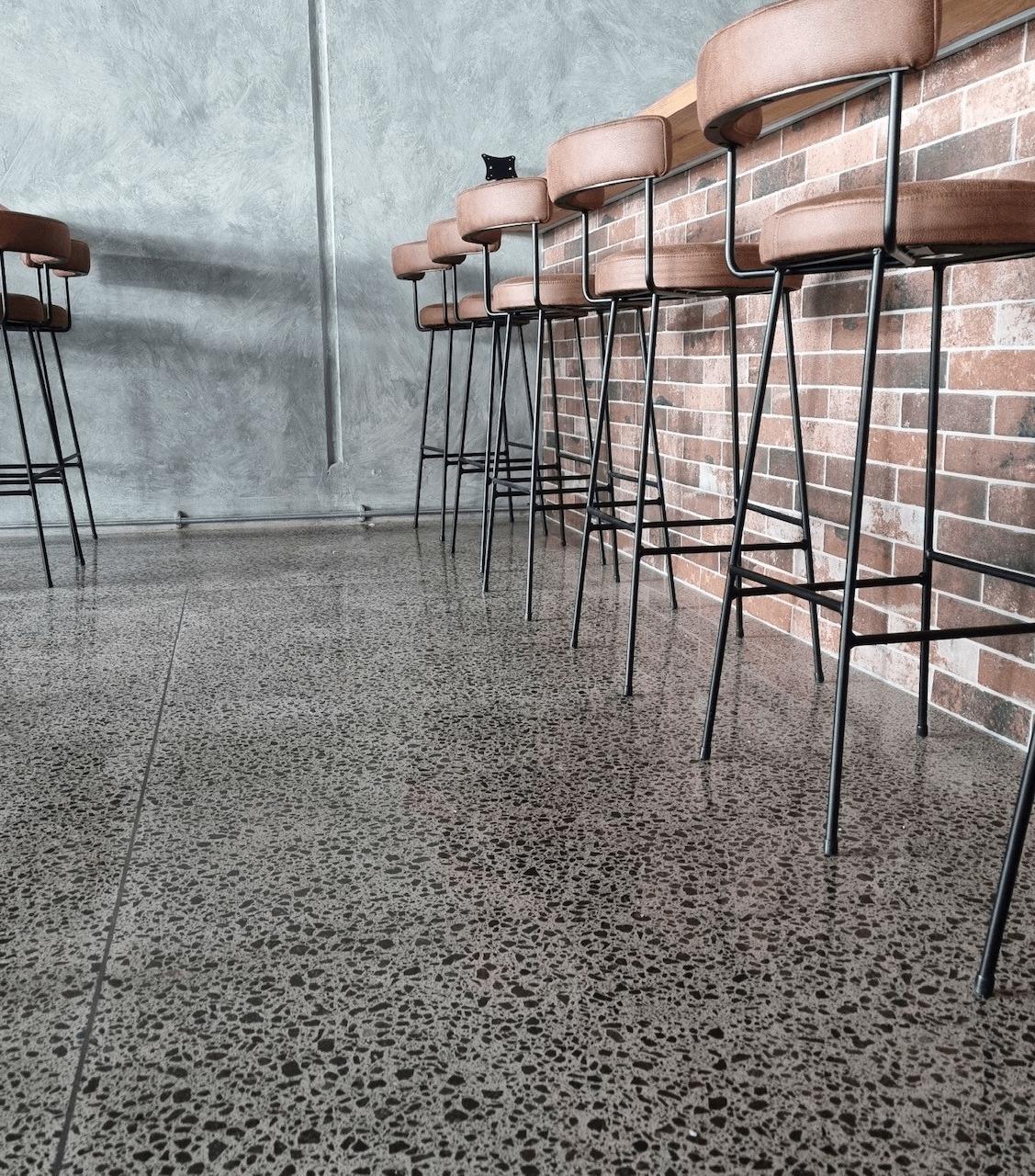 saltwater restqaurant polished concrete floor tauranga nz grinders close up of a polished concrete floor at saltwater restaurant with barstools to the right and a brick bar upstand